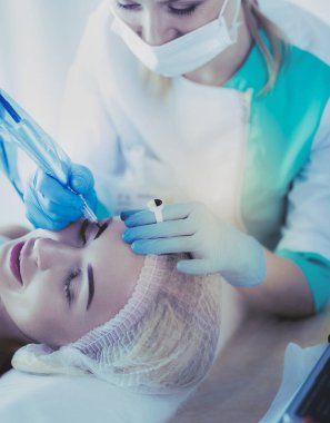 Kaşlar için kalıcı makyaj. Güzellik salonunda kalın kaşlı güzel bir kadın.