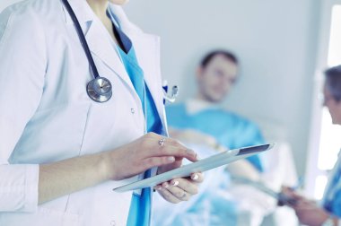 Hastane lobisinde tablet bilgisayar kullanan kadın doktor.