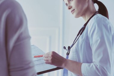 Güzel bayan doktor bir hastaya tıbbi tedaviyi açıklıyor.