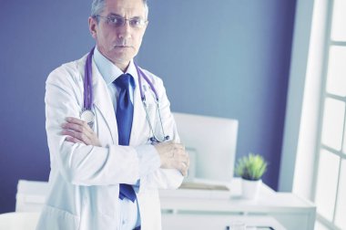 Parlak ofisinde gülümseyen bir doktorun portresi.