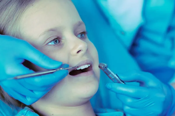 Niña sentada en el consultorio de dentistas. —  Fotos de Stock