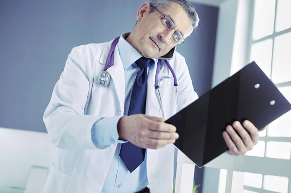 Male doctor writes notes on the clipboard in the hospital