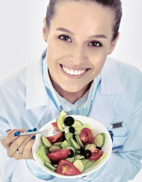 Portret pięknej pani doktor trzymającej talerz ze świeżymi warzywami. — Zdjęcie stockowe
