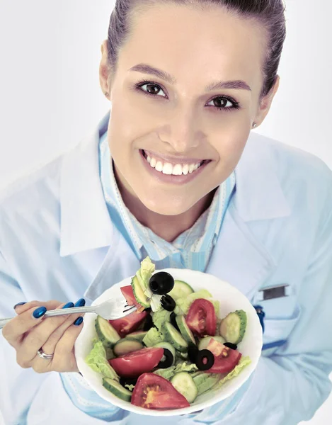 Portrait of a beautiful woman doctor holding a plate with fresh vegetables. — Stock Photo, Image