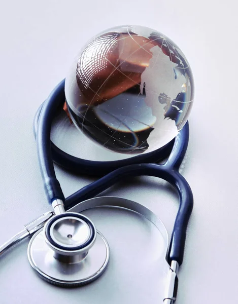 Global healthcare. Globe and stethoscope on white background — Stock Photo, Image