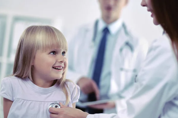 Female doctor examining child with stethoscope at surgery — Stock Photo, Image