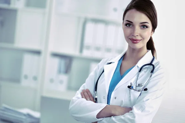 Портрет молодой женщины-врача в белом халате, стоящей в больнице — стоковое фото