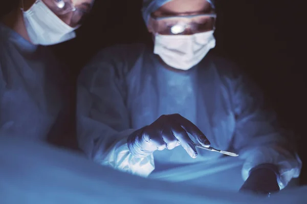 Cropped picture of scalpel taken doctors performing surgery. — Stock Photo, Image