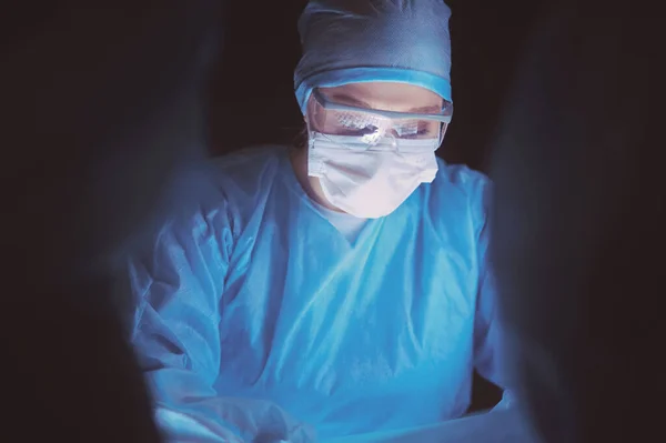Команда лікарів в хірургії на темному фоні . — стокове фото