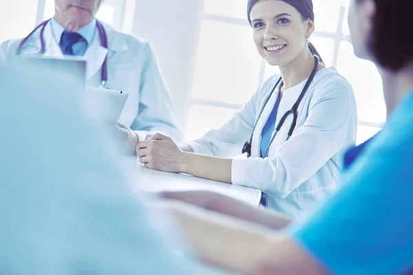 Equipo médico serio discutiendo casos de pacientes en un consultorio luminoso —  Fotos de Stock