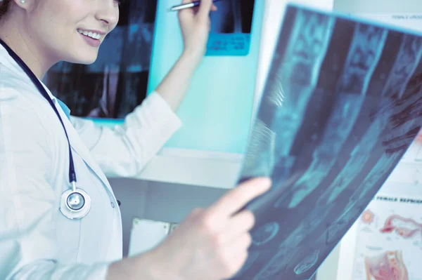 Giovane dottoressa che guarda l'immagine a raggi X dei polmoni in ospedale — Foto Stock