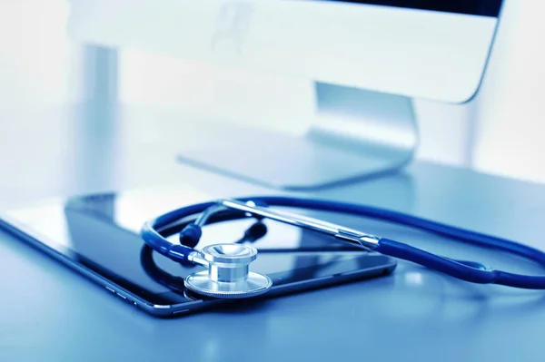 Matériel médical : stéthoscope bleu et comprimé sur fond blanc. Matériel médical — Photo