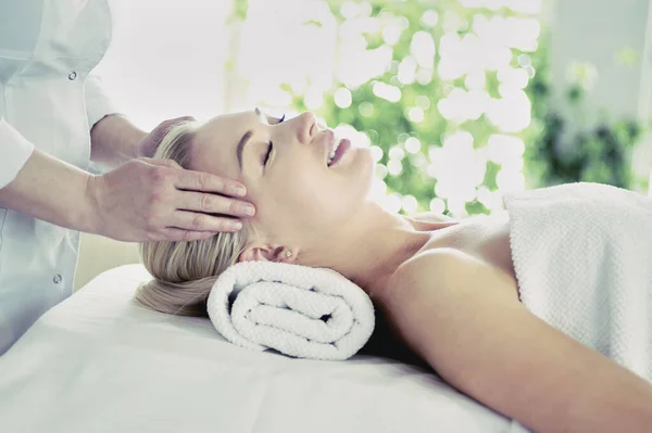 Hermosa mujer haciendo masaje facial en un salón de spa — Foto de Stock