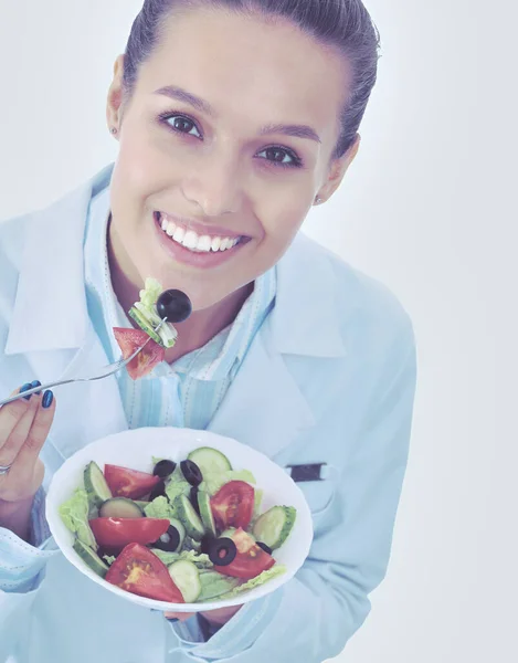 Portrait d'une belle femme médecin tenant une assiette avec des légumes frais. Femmes médecins. — Photo