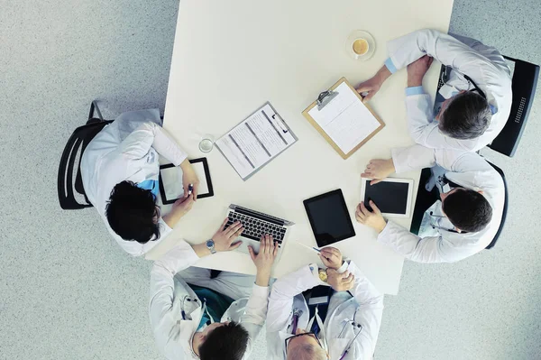 Medicinskt team sitter och diskuterar vid bordet, ovanifrån — Stockfoto