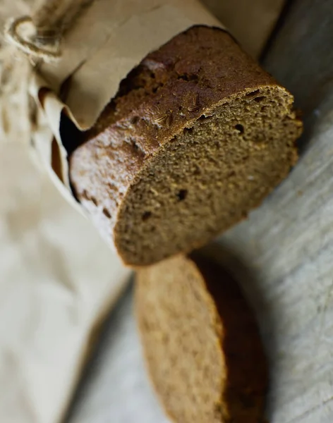 Sliced loaf of Bread packed in paper on wooden table