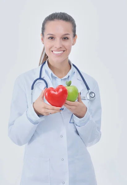 Mooie glimlachende vrouwelijke arts met rood hart en groene appel. Vrouwelijke dokter — Stockfoto