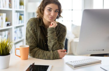 Öğrenci evdeki bir masada dizüstü bilgisayarla çalışıyor ve öğreniyor.