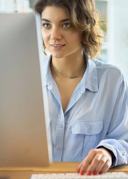 Femme heureuse travaillant en utilisant plusieurs appareils sur un bureau à la maison — Photo