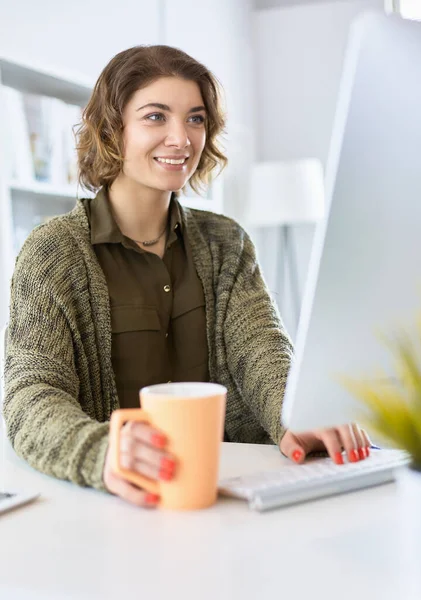 Öğrenci evdeki bir masada dizüstü bilgisayarla çalışıyor ve öğreniyor.