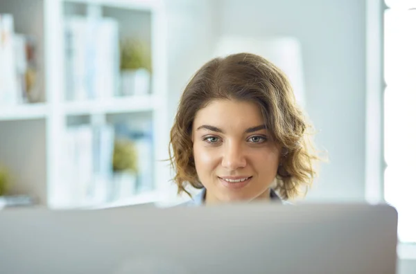 Happy woman working using multiple devices on a desk at home