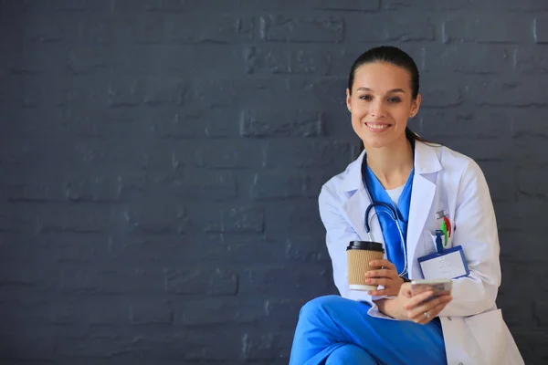 Een jonge vrouwelijke dokter die bij je telefoon zit. Vrouwelijke artsen. — Stockfoto