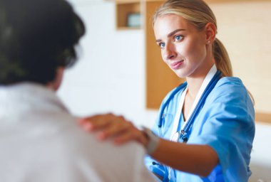 Doktor ve hasta tarama sonuçlarını tarama merkezinde tartışıyor