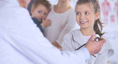 Steteskoplu kız ve doktor kalp atışlarını dinliyor.