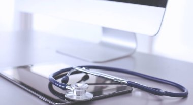 Tıbbi ekipman: Beyaz arka planda mavi steteskop ve tablet. Tıbbi ekipman