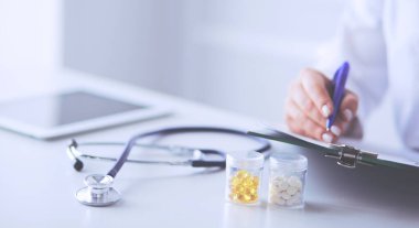 Steteskop cam masanın üzerinde duruyor. Yoğun bir doktor geçmişinde dizüstü bilgisayarı var. İlaç ya da eczane konsepti. Doktor çalışma masasında tıbbi aletler