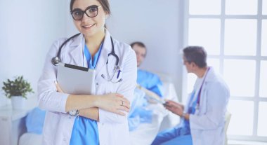 Hastane lobisinde tablet bilgisayar kullanan kadın doktor.