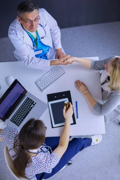 Médico e paciente discutindo algo enquanto se senta na mesa. Conceito de medicina e cuidados de saúde — Fotografia de Stock