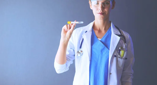 Ženská lékařka nebo výzkumná vědkyně nebo lékařka, která se dívá na zkumavku s čirým roztokem v laboratoři nebo laboratoři — Stock fotografie