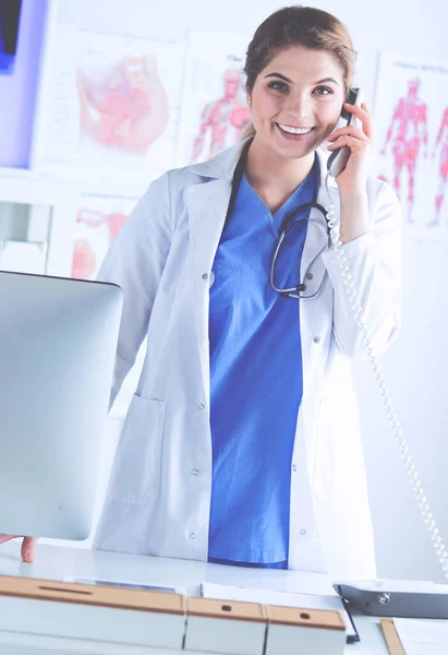 Serieuze dokter aan de telefoon in haar kantoor — Stockfoto