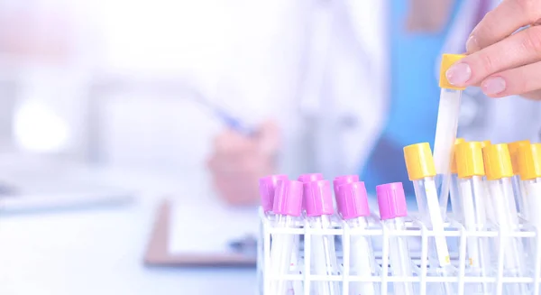 Woman researcher is surrounded by medical vials and flasks, isolated on white background — Stock Photo, Image