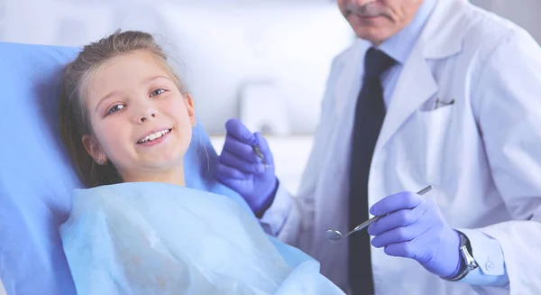 Niña sentada en el consultorio de dentistas — Foto de Stock