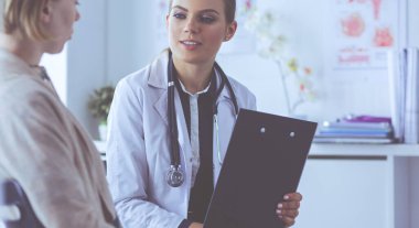 Doktor ve hasta masada otururken bir şey tartışıyorlar. İlaç ve sağlık hizmetleri kavramı