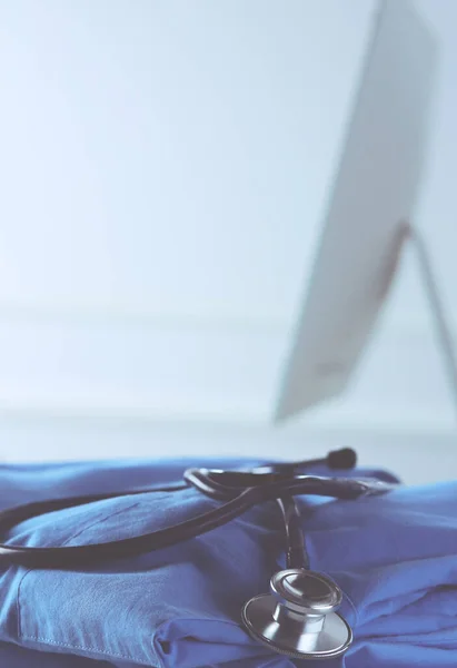 Immagine di stetoscopio e cappotto medico sul tavolo in una sala di consulenza. Concetto medico — Foto Stock