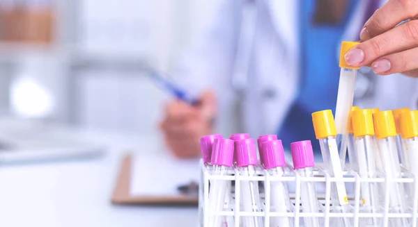 Woman researcher is surrounded by medical vials and flasks, isolated on white background — Stock Photo, Image