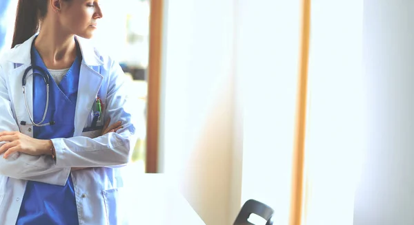 Женщина-врач со стетоскопом стоит со скрещенными руками — стоковое фото