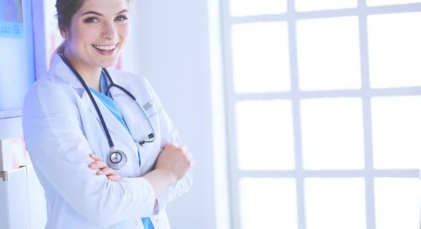 Young woman medic in white uniform standing in clinics office — Stock Photo, Image