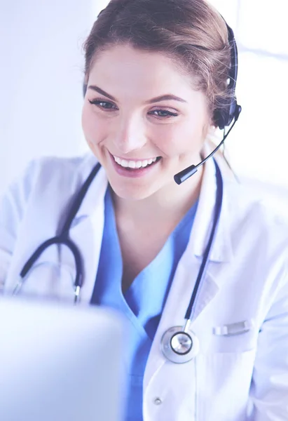 Doctor wearing headset sitting behind a desk with laptop — Stock Photo, Image