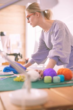 Genç girişimci kadınlar ve atölyesi üzerinde çalışan moda tasarımcısı.