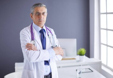 Parlak ofisinde gülümseyen bir doktorun portresi.