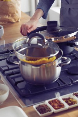 Mutfakta ahşap kaşıkla yemek pişiren kadın