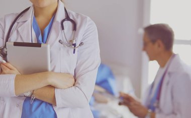 Hastane lobisinde tablet bilgisayar kullanan kadın doktor.