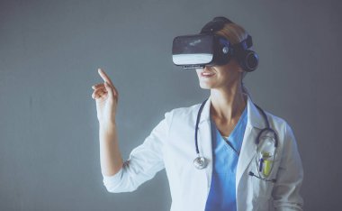 Sanal gerçeklik gözlüğü takan kadın doktor beyaz arka planda izole edilmiş..