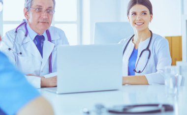 Parlak bir ofiste çalışan ciddi bir tıbbi ekip.