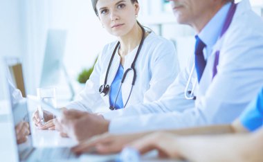 Doktorlar hastane konferans odasında birbirlerine danışıyorlar.