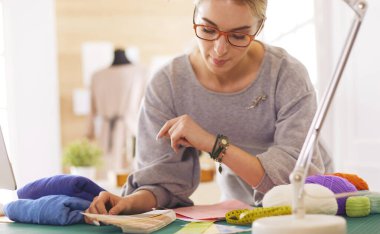 Atölyede çalışan Amerikalı kadın moda tasarımcısı